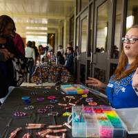 Student merchant talking with patrons during Student Small Business Market.